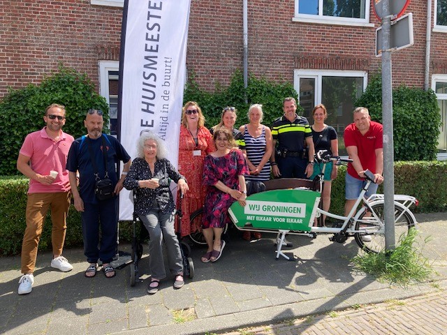 Een mobiele koffiekar (een bakfiets) met daarachterbuurtbewoners